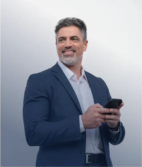 Smiling businessman in a navy suit holding a smartphone